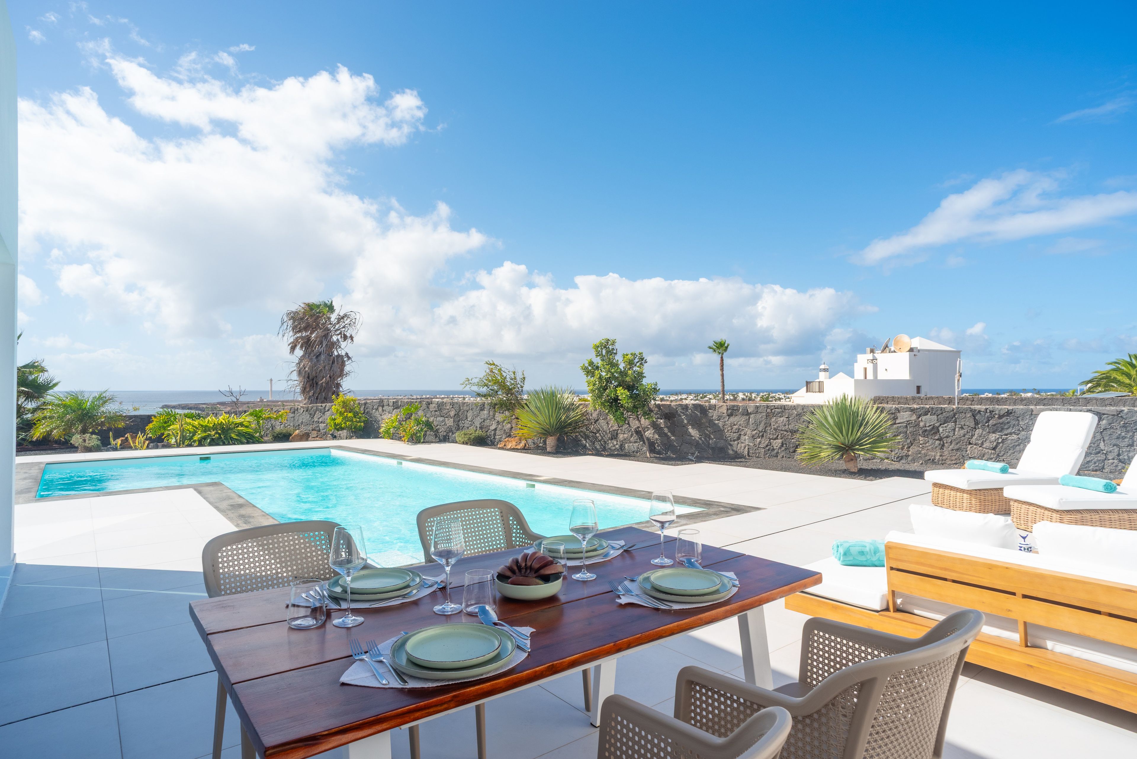 Mesa para cuatro personas con vista al mar y cielo despejado.