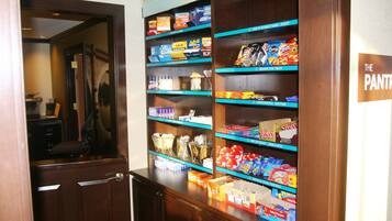 Un bar servant des collations, où l’on trouve divers produits alimentaires, et une pancarte indiquant qu’il s’agit de l’espace réservé aux provisions.
