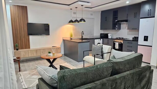 Una sala de estar moderna con un sofá, una mesa de centro y un televisor.