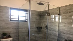 Un baño moderno con ducha envuelta en vidrio, inodoro y lavamanos.