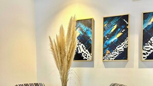 A dining area with a round table, striped chairs, and abstract wall art. - Contemporary Haven in the Heart of La Marsa (La Marsa)