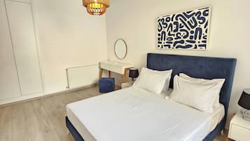 A bedroom with a bed, a bedside table, a lamp, a wall art piece, and a hanging light fixture.