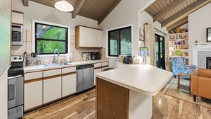 Cozinha moderna com armários de madeira, lava-louças e uma ilha grande.
