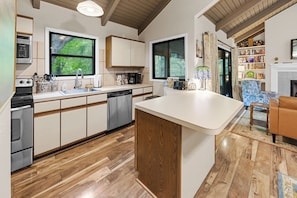 A modern kitchen with wooden cabinets, a dishwasher, and a large island. - The Chestnut Hideaway - Big Canoe Resort (Jasper)