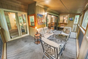A cozy interior with a sofa, armchairs, and a coffee table, featuring a wooden floor and a large window. - The Chestnut Hideaway - Big Canoe Resort (Jasper)