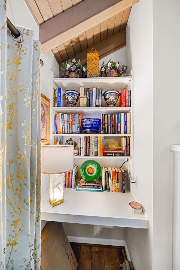 A bookshelf with various books, decorative items, and a lamp.
