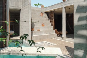 A modern architectural structure with concrete walls, a wooden deck, and a staircase leading to an interior space. - Marvelous 3-bedroom house in Puerto Escondido near the beach (puerto escondido)