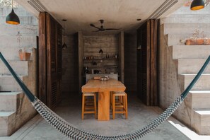 A dining area with a wooden table and chairs, a ceiling fan, and a hammock. - Marvelous 3-bedroom house in Puerto Escondido near the beach (puerto escondido)