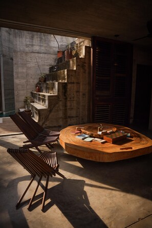 A circular wooden table with books and a kettle, surrounded by a concrete staircase and a wooden bench. - Marvelous 3-bedroom house in Puerto Escondido near the beach (puerto escondido)