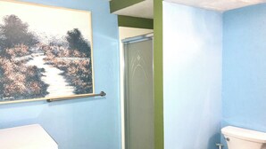 Une salle de bain avec des toilettes, une douche et un lavabo.