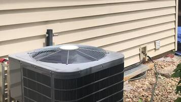 Un appareil de climatisation extérieur installé sur le mur extérieur d’une maison.