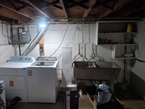A laundry room with a washer, dryer, and metal sink.