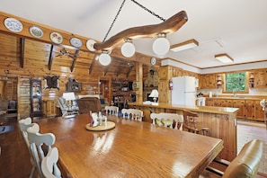 Un'accogliente cucina in legno con un grande tavolo da pranzo, mobili in legno e un camino in pietra.