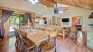 A spacious cabin interior with a large dining table, multiple chairs, ceiling fans, and a kitchen area. - LeVasseur Cabin  Simple Escape (Murphy)