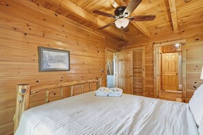 A wooden room with a bed, a ceiling fan, and a framed picture on the wall. - Hanging Out in the Clouds (Blue Ridge)