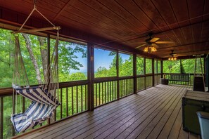 A wooden deck with a hammock, a ceiling fan, and a bench. - Hanging Out in the Clouds (Blue Ridge)