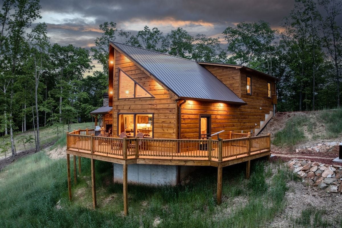 Een houten chalet met terras, omringd door bomen.