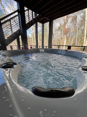 Ein Whirlpool mit Blick auf Bäume, eingebettet in eine überdachte Struktur.