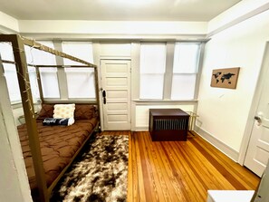 A room with a bunk bed, a small table, a radiator, and a world map on the wall. - Charming Vintage Loft in Bishop Arts (Dallas)