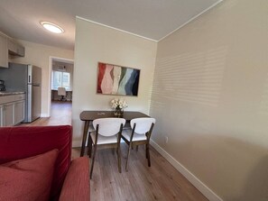A compact living space with a dining area, kitchenette, and a red couch. - Poolside 1BR in the Heart of Central Austin (Austin)