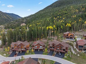 A cluster of wooden cabins with a mountain backdrop, surrounded by dense forest. - NEW! The Alders - Walk 2 Ski, Hot Tub, Fireplace (Dillon)