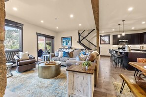 A spacious living area with a sofa set, a coffee table, and a dining table. - NEW! The Alders - Walk 2 Ski, Hot Tub, Fireplace (Dillon)