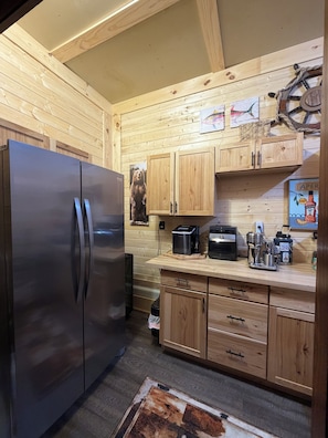 A kitchen with wooden cabinets, a stainless steel refrigerator, and various appliances.