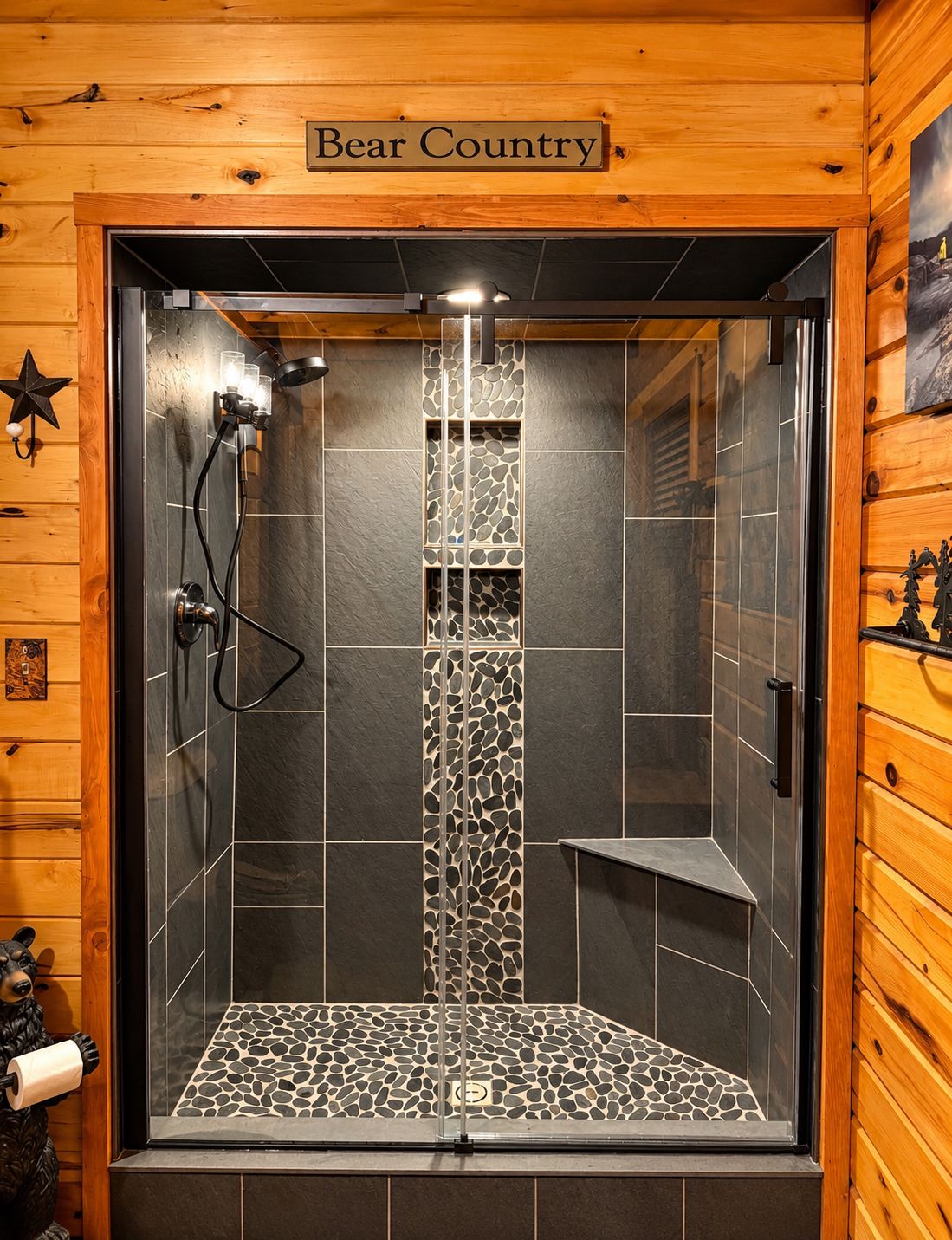Um chuveiro com design em mosaico de pedra, uma porta de madeira com uma placa que diz 'Bear Country' e uma estrela decorativa na parede.