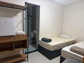 A compact hotel room with a bed, a small desk, a wardrobe, and a bathroom. - Pousada SMART AIRPORT 10min (Guarulhos)