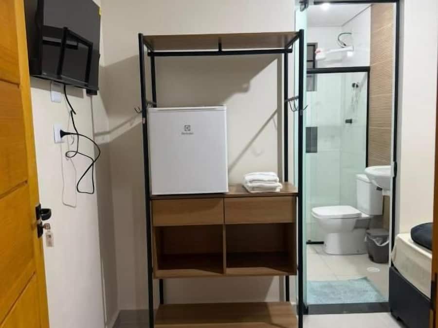 A compact bathroom with a shower area, a toilet, and a sink.