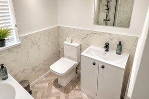 Une salle de bain moderne équipée de toilettes, d’un lavabo et d’une douche.