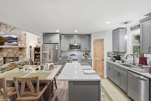 Una cocina moderna con encimeras de granito, electrodomésticos de acero inoxidable y armarios grises.