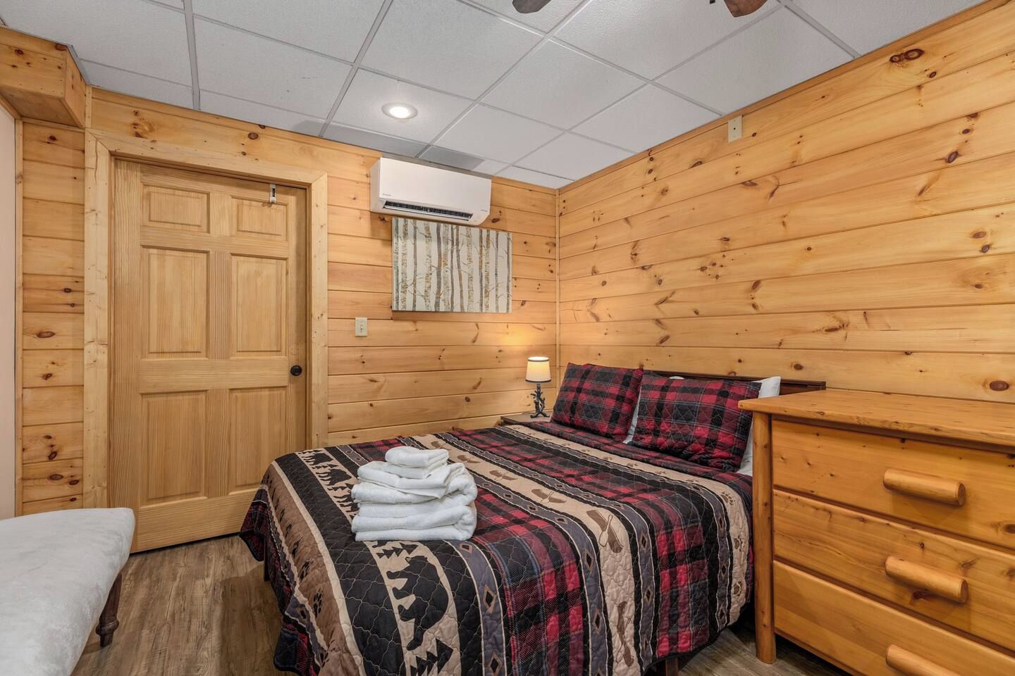 Ein Zimmer mit einem Bett, einem Schminktisch und einer Klimaanlage.