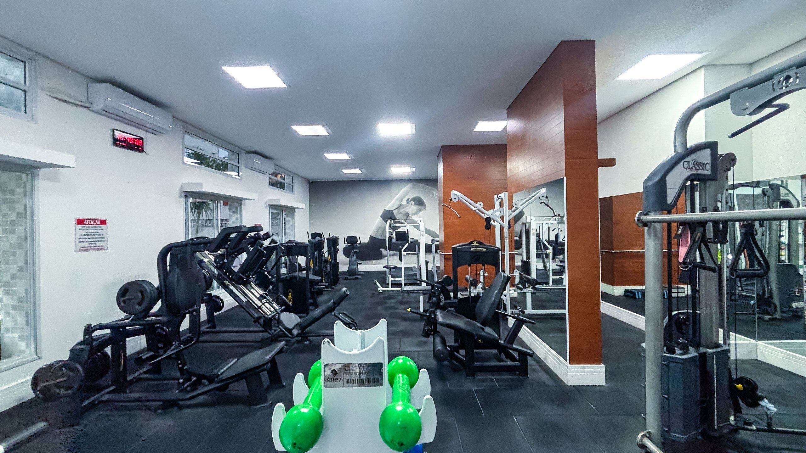 Un gimnasio con diversos equipos de ejercicio, incluyendo máquinas de pesas y pesas libres.