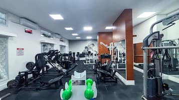 Un gimnasio con diversos equipos de ejercicio, incluyendo máquinas de pesas y pesas libres.