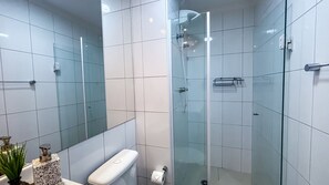 A modern bathroom with a glass shower enclosure, a toilet, and a sink. - SHB - Alto Padrão com Lazer Completo (Guarujá)