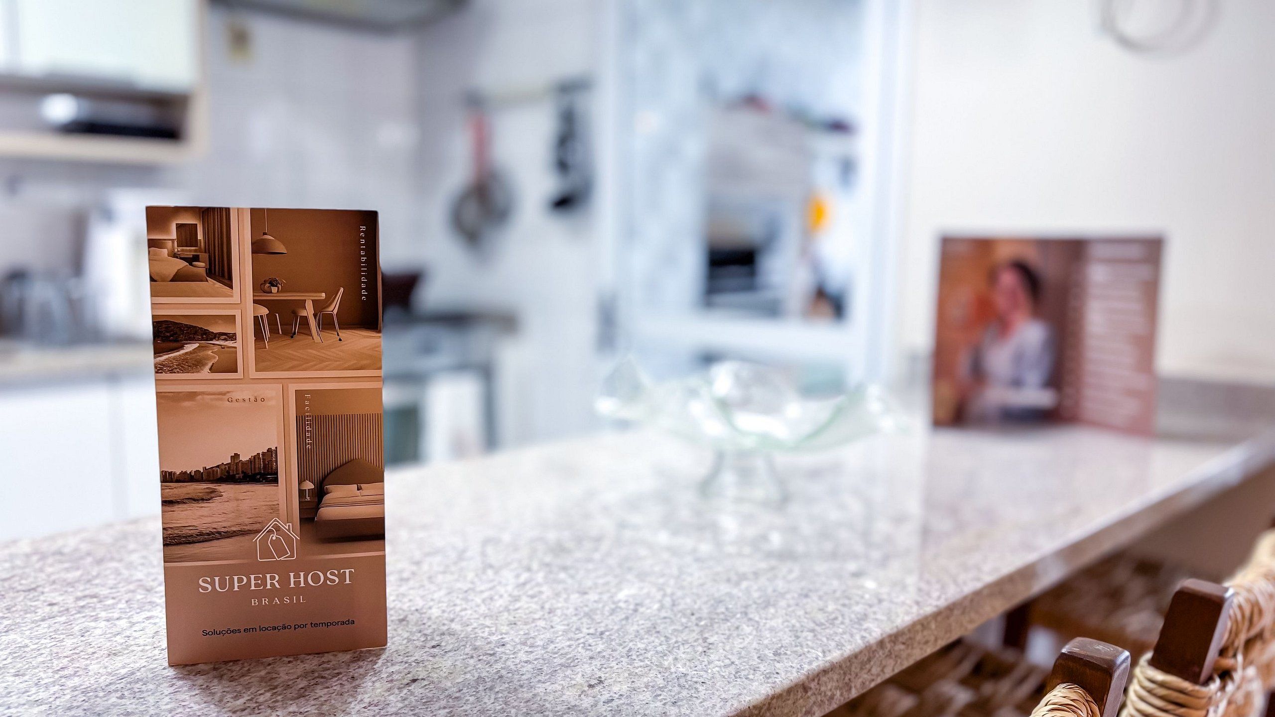 A brochure titled 'SUPER HOST BRASIL' on a kitchen counter with a blurred background.