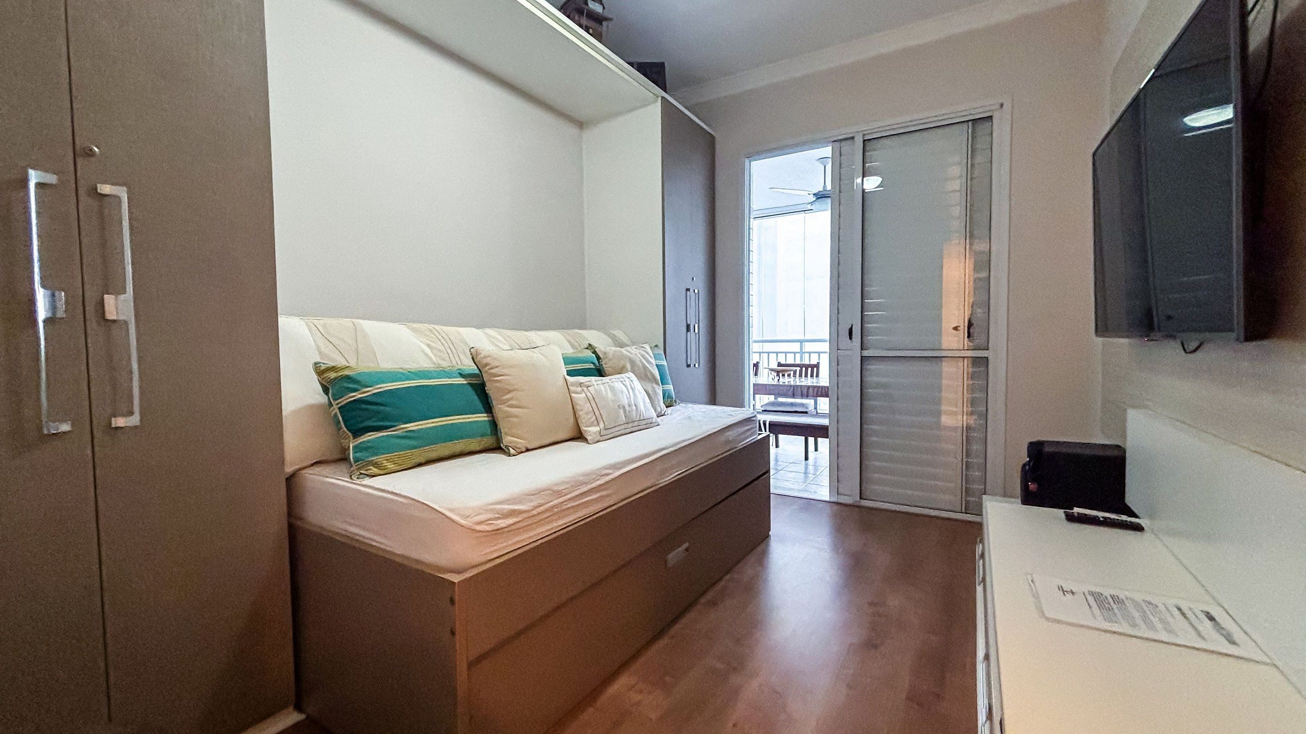 Un dormitorio pequeño con cama, armario y televisión.