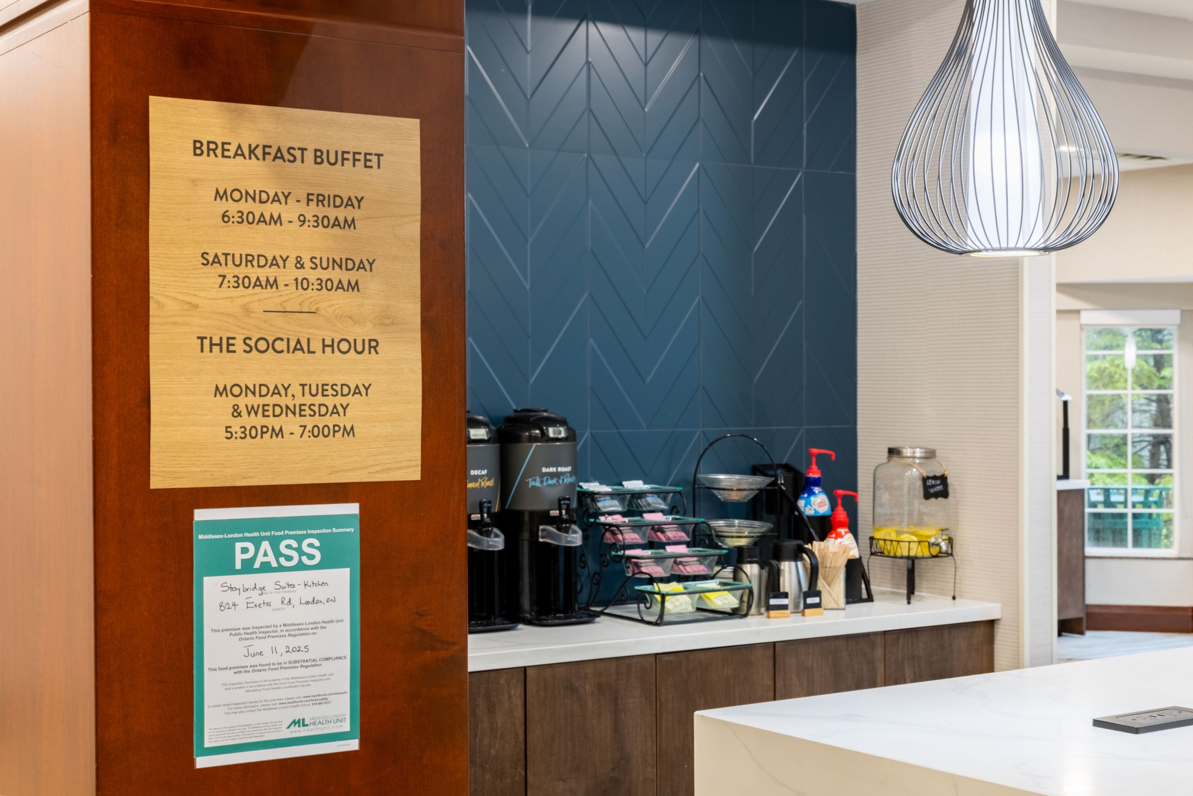 Un panneau indiquant le buffet du petit-déjeuner, avec les heures d’ouverture, un espace dédié au café et un document attestant du contrôle sanitaire.