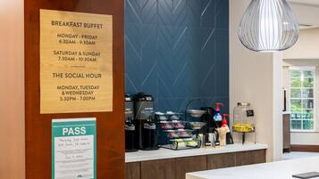 Un panneau indiquant le buffet du petit-déjeuner, avec les heures d’ouverture, un espace dédié au café et un document attestant du contrôle sanitaire.