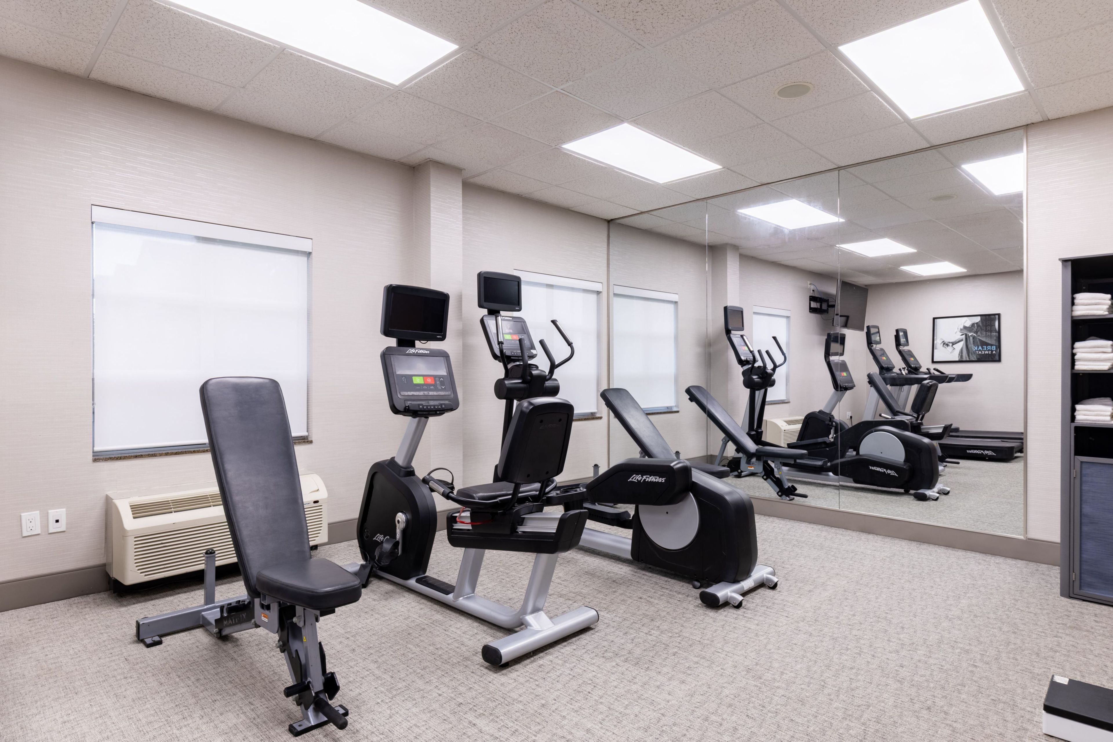 A gym with stationary bikes, a treadmill, and a weight bench.