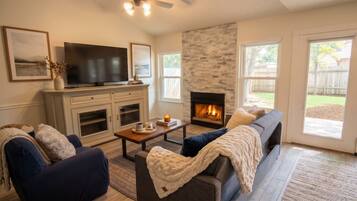 A living room with a fireplace, a television, and a sofa.