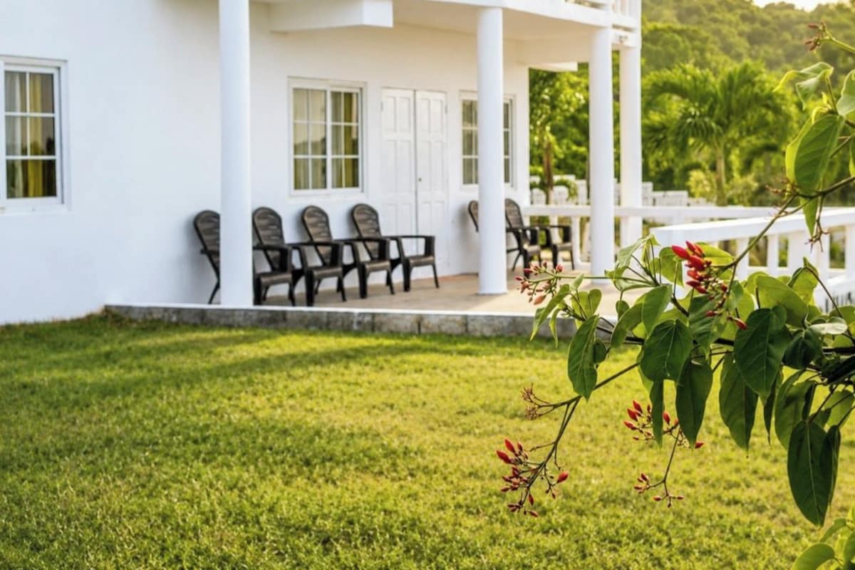 A white building with a covered porch and outdoor seating.
