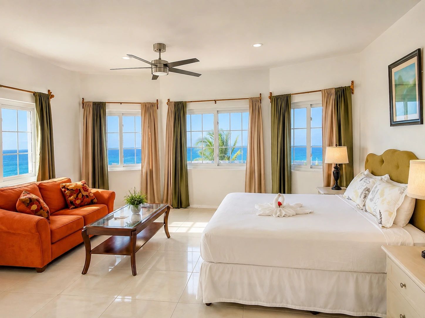 Una habitación de hotel con una cama, un sofá, una mesa de centro y vista al mar.