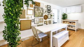 A modern dining area with a white table, gold chairs, and a bench.