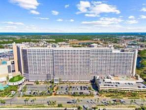 A large hotel with multiple floors, a parking lot, and a pool area. - Blue View Retreat at Laketown Wharf 720 - Ocean View, 3BR, Gym, Pools, Parking (Panama City Beach)