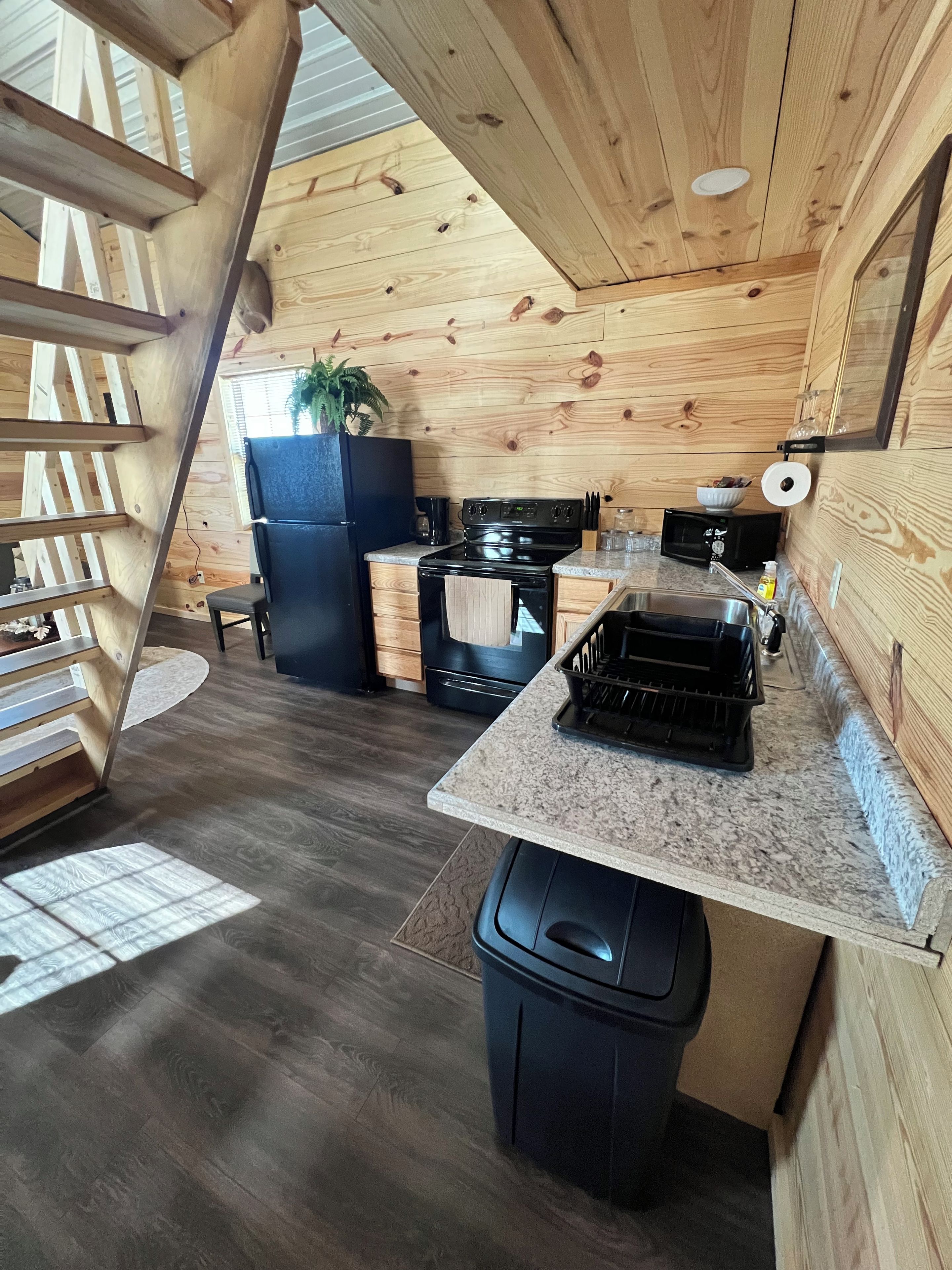 A compact kitchen with a built-in stove, microwave, and a small sink.