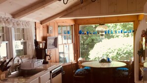 A kitchen with wooden cabinets, a sink, and a dining area with a table and chairs. - Berkshires 4br/2ba. Avail Fall, Winter, & Spring. (New Lebanon)
