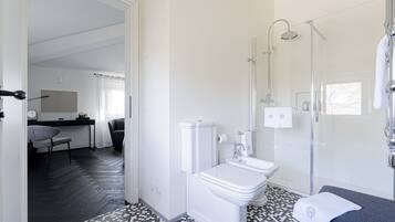 A modern bathroom with a toilet, sink, and shower.