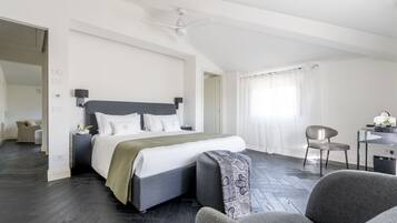 A modern bedroom with a large bed, a desk, and a chair.